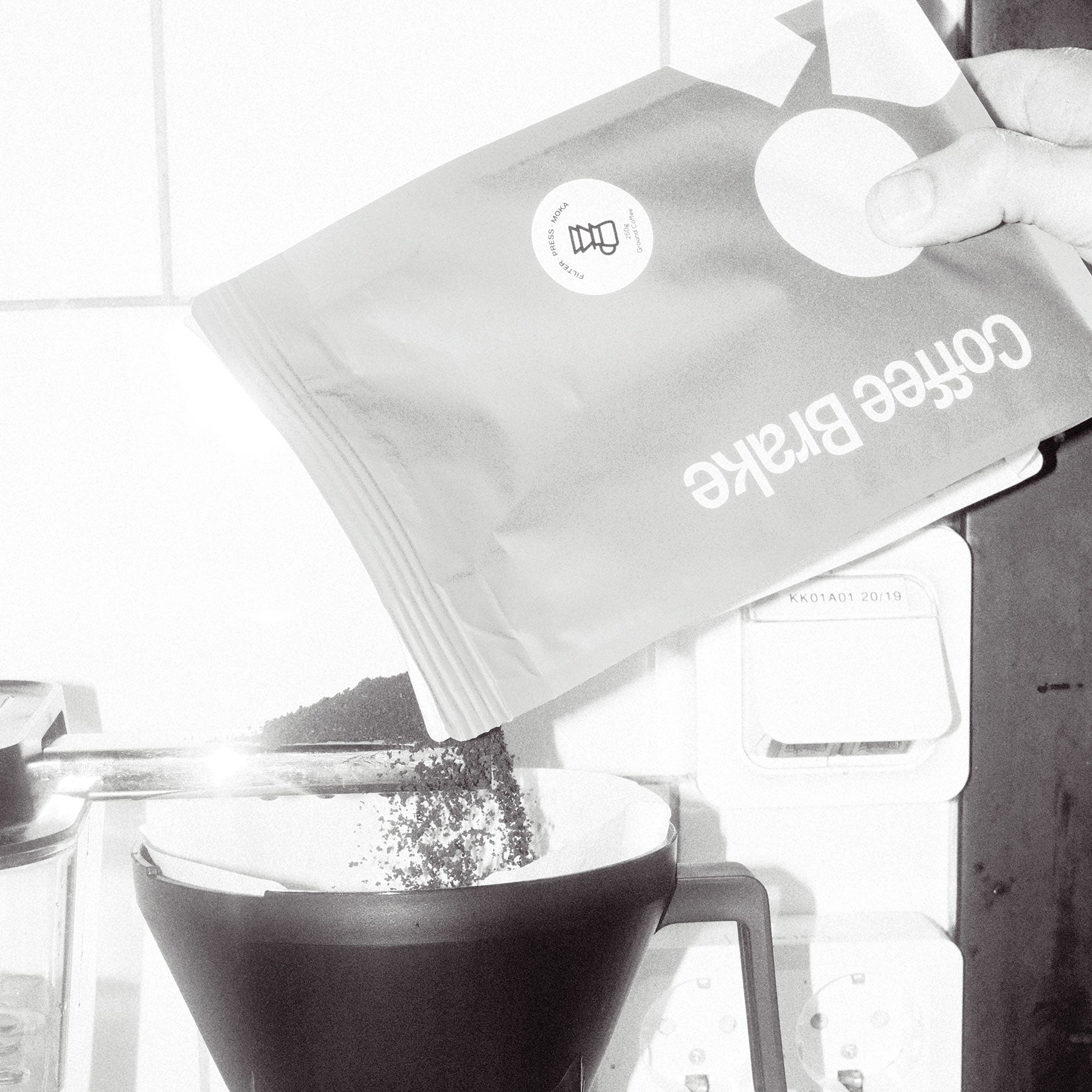 Coffee bag labeled 'Coffee Brake' being poured into a moccamaster.